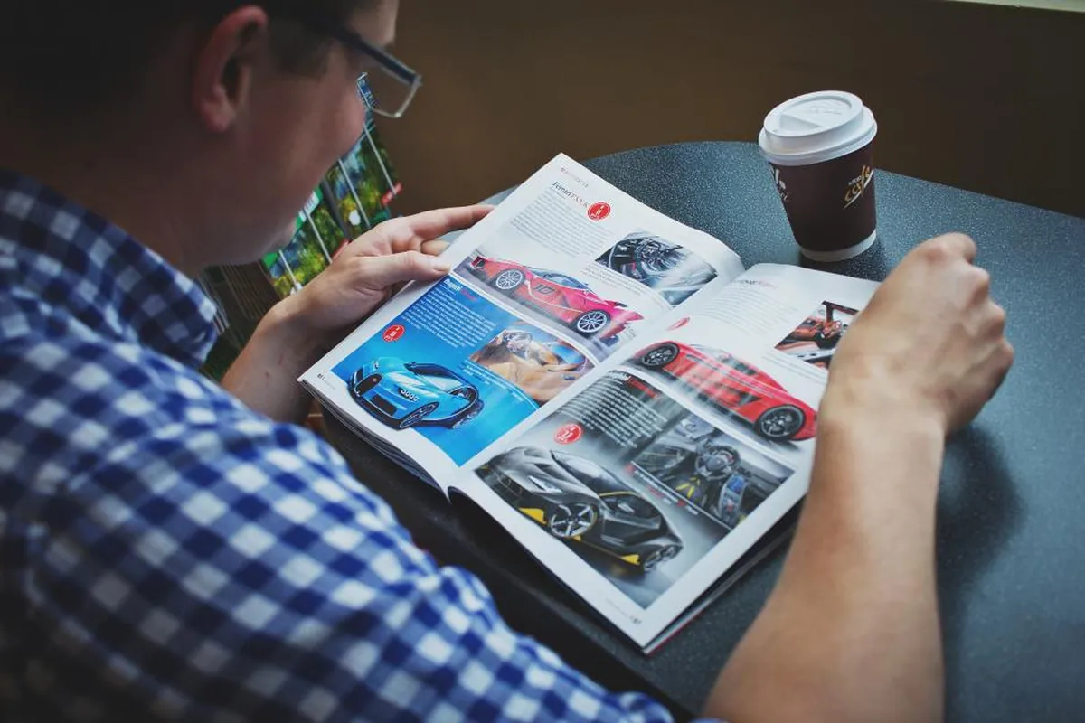 Welcome to NeWorldsMagazine.com: What We Cover and Why It Matters Man reading a glossy magazine at a table with a coffee cup